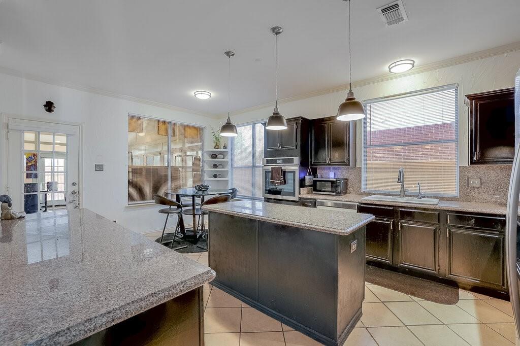 706 Gentry Drive Arlington, TX 76018 - Photo 15 of 39 a kitchen with stainless steel appliances granite countertop a sink counter space cabinets and stainless steel appliances