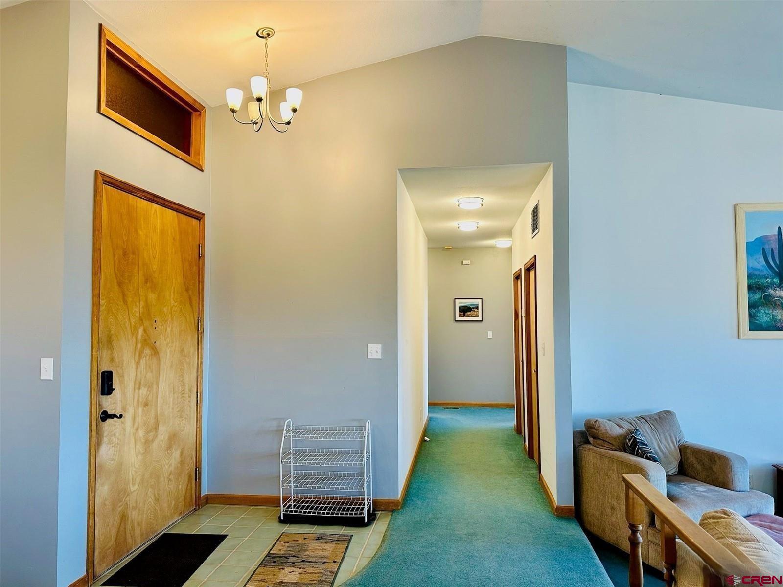 105 Indian Hill Road Mosca, CO 81146 - Photo 6 of 38 Front door entrance is a solid 36" wood door. The hallway to the south leads to the primary bedroom to the right and left to the 2nd and 3rd bedrooms.