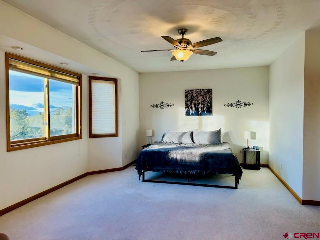 105 Indian Hill Road Mosca, CO 81146 - Photo 7 of 38 Primary bedroom is spacious with west facing windows - new ceiling fan.