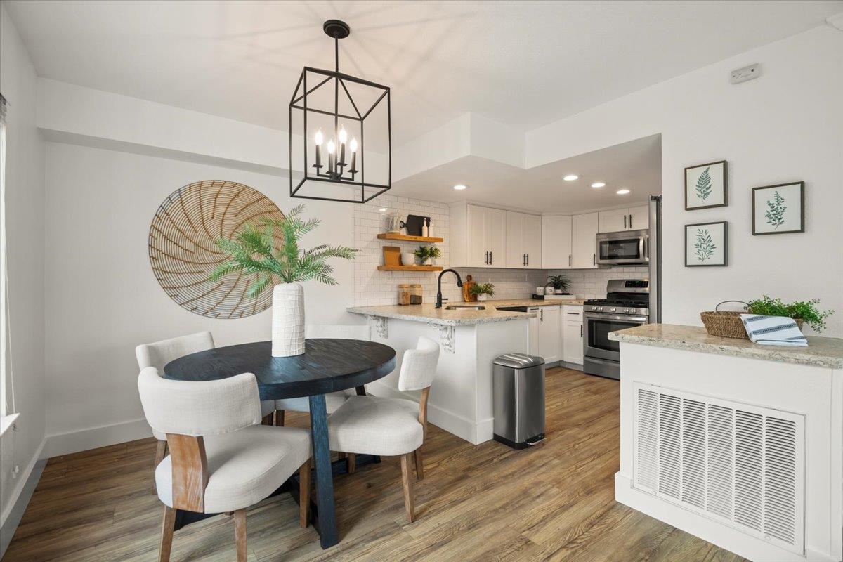 16761 San Luis Way Morgan Hill, CA 95037 - Photo 5 of 35 a kitchen with stainless steel appliances kitchen island granite countertop a table chairs and a wooden floor