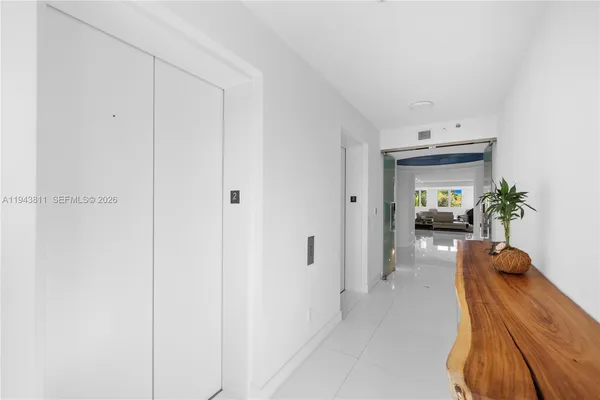 a view of a hallway to a livingroom and a gallery with wooden floor