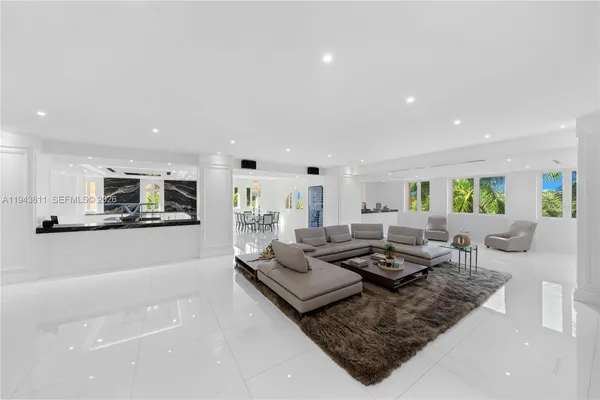 a living room with furniture and a view of kitchen