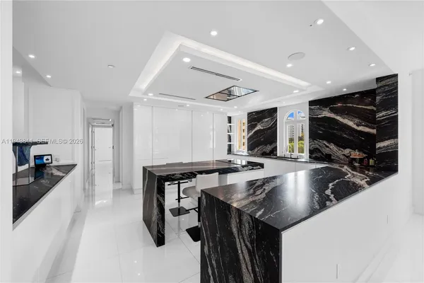 a kitchen with stainless steel appliances granite countertop a sink a counter and chairs