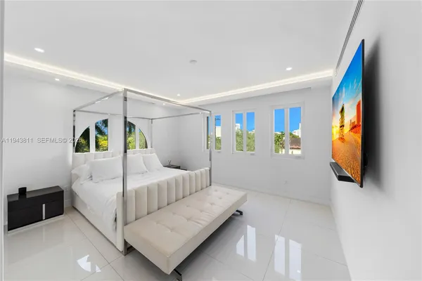 a bedroom with a bed and a flat screen tv