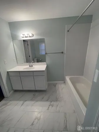 a bathroom with a sink a tub and a mirror