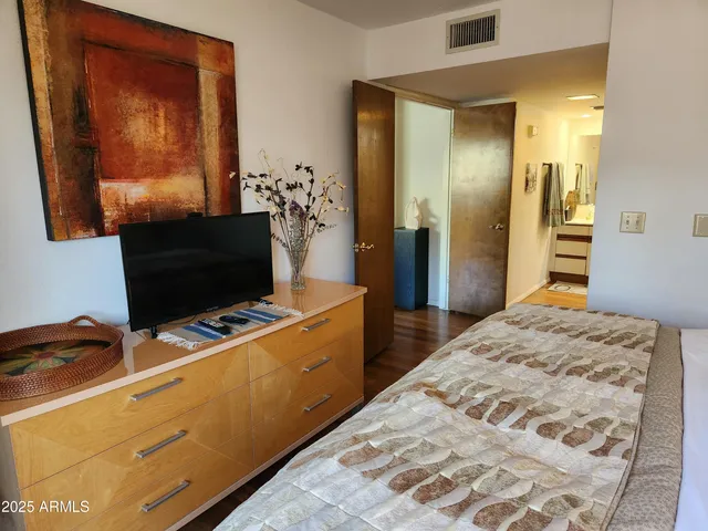 a bedroom with a bed and a flat screen tv