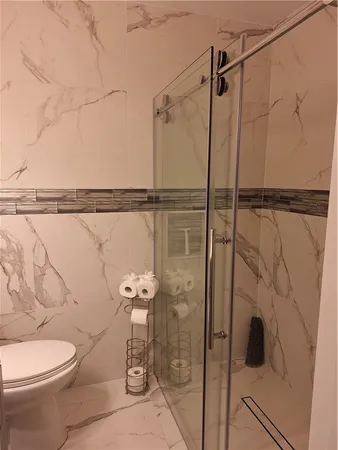 a bathroom with a shower a toilet and a shower