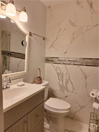 a bathroom with a sink mirror vanity and toilet