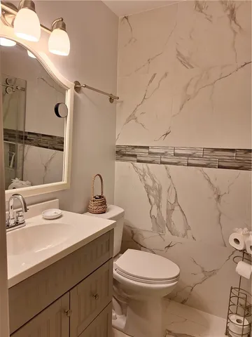 a bathroom with a sink mirror vanity and toilet