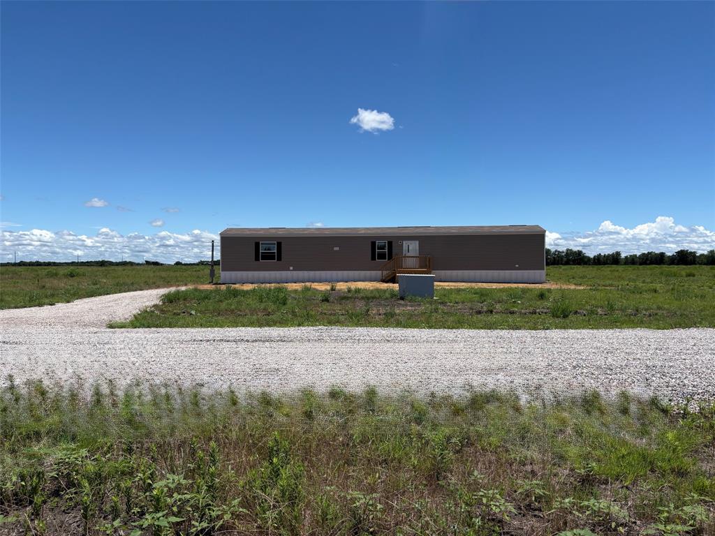 0 Southeast 4060 Road, Unit 25 Kerens, TX 75144 - Photo 1 of 18 Single-story residence featuring neutral-toned siding, a gravel driveway, and a partially covered foundation