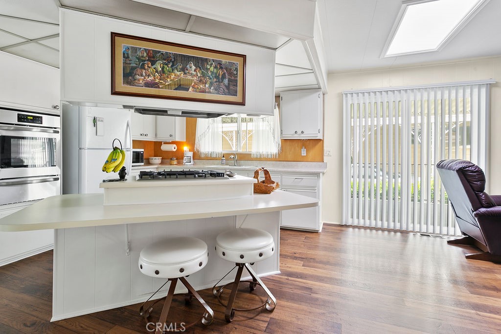 24921 Muirlands Boulevard, Unit 23 Lake Forest, CA 92630 - Photo 13 of 27 a view of a kitchen with workspace and wooden floor