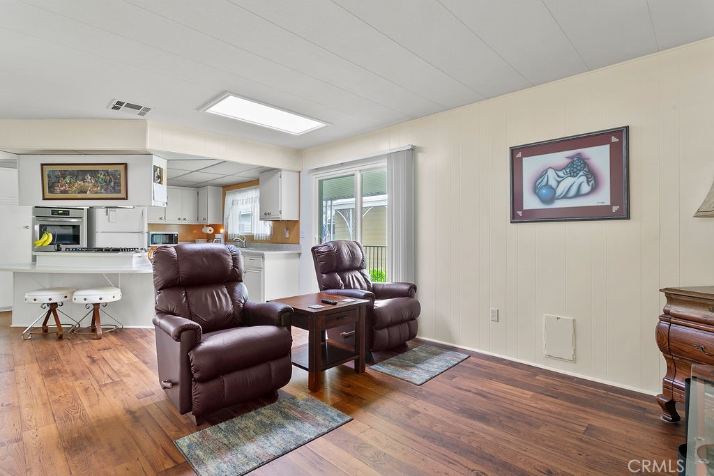 24921 Muirlands Boulevard, Unit 23 Lake Forest, CA 92630 - Photo 16 of 27 a living room with furniture and a wooden floor