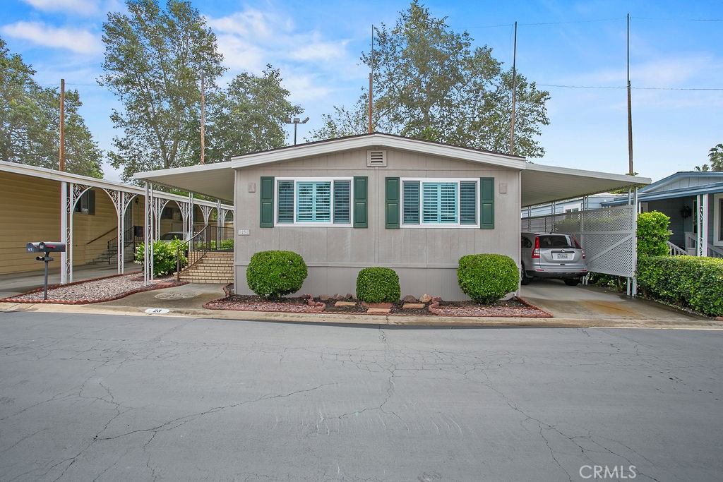 24921 Muirlands Boulevard, Unit 23 Lake Forest, CA 92630 - Photo 2 of 27 a front view of a house with a yard and garage