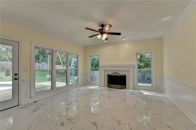 a view of an empty room with window and wooden floor