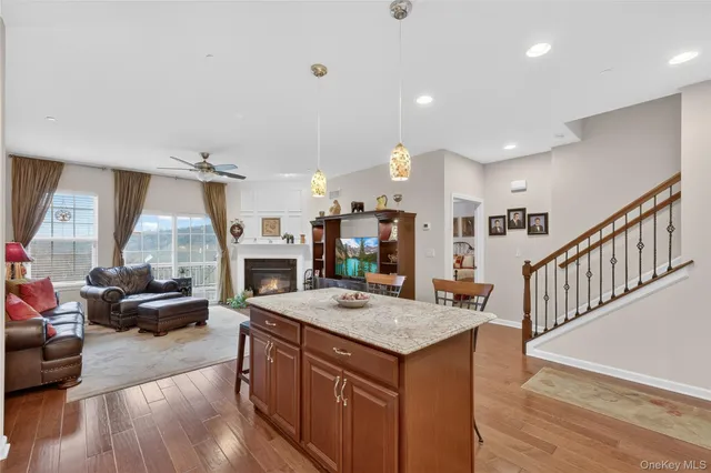 a kitchen with stainless steel appliances granite countertop a stove refrigerator a sink dishwasher a dining table and chairs with wooden floor