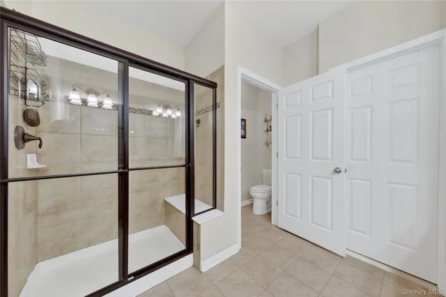 a bedroom with a bed a chandelier and dresser