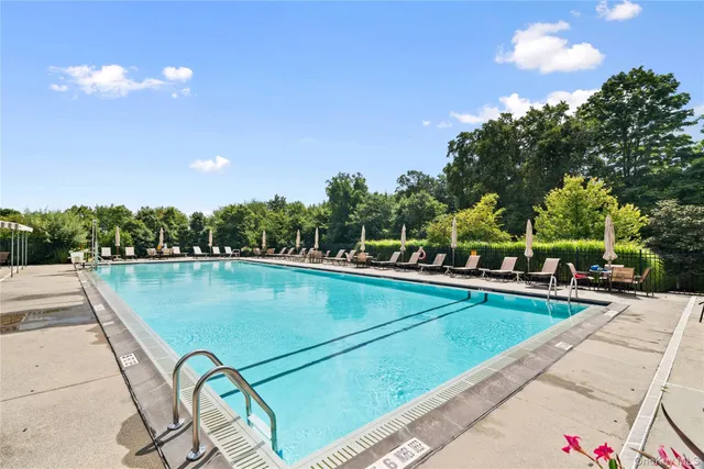 a view of multiple houses with yard and swimming pool