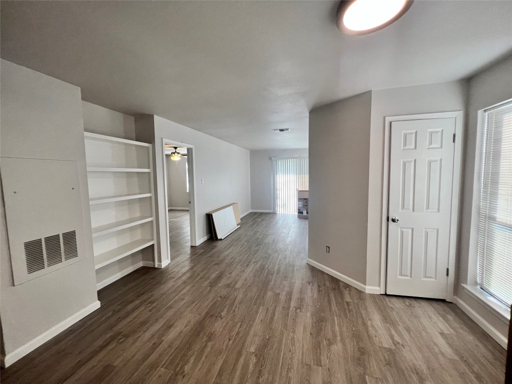2008 West Loop, Unit B Austin, TX 78758 - Photo 6 of 11 Unfurnished living room with dark wood-style floors, built in features, and ceiling fan