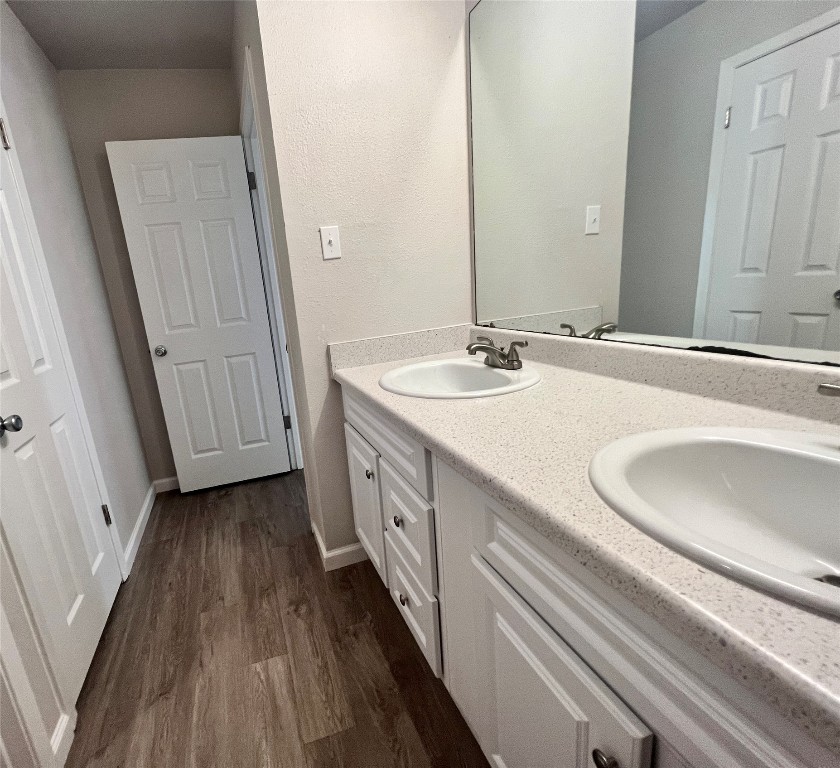2008 West Loop, Unit B Austin, TX 78758 - Photo 10 of 11 Bathroom featuring double vanity and dark wood-style flooring