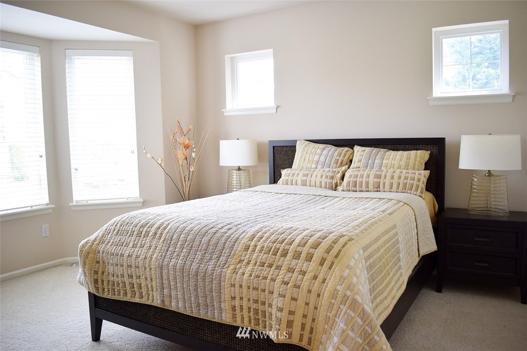 1217 South 36th Place Renton, WA 98055 - Photo 11 of 15 a large bed sitting in a bedroom next to a window