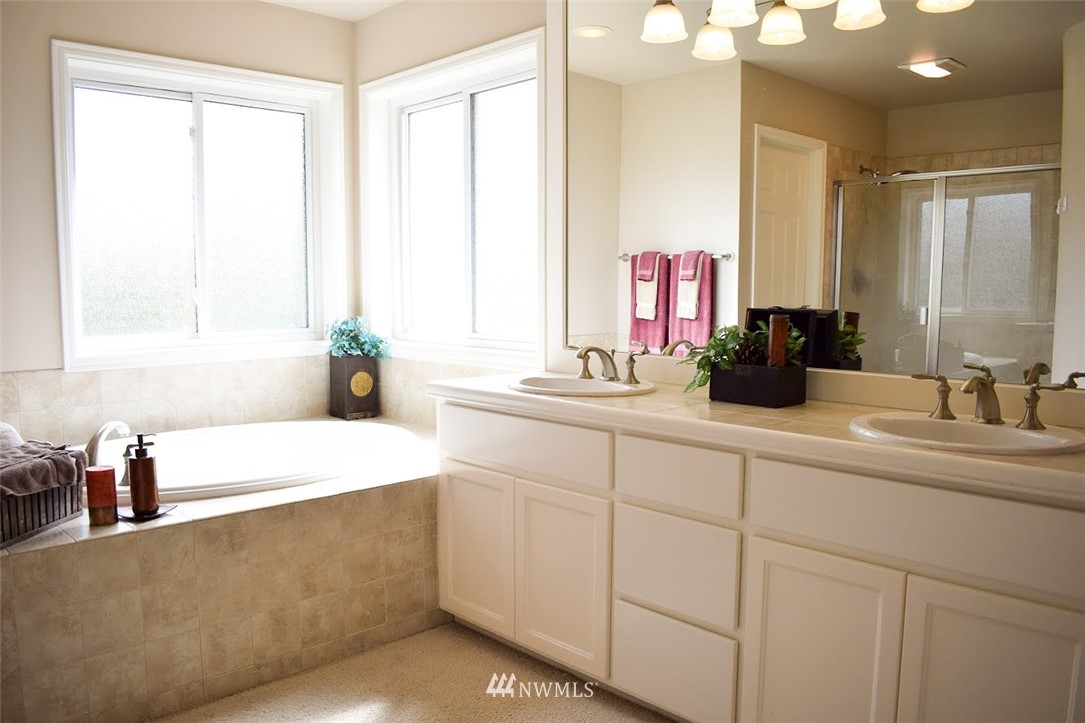 1217 South 36th Place Renton, WA 98055 - Photo 14 of 15 a bathroom with a sink tub double vanity and mirror