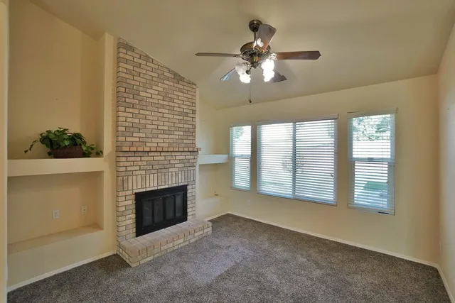 a view of empty room with wooden floor and fireplace