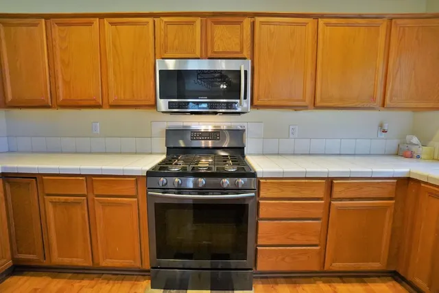 a view of kitchen with granite countertop cabinets and refrigerator
