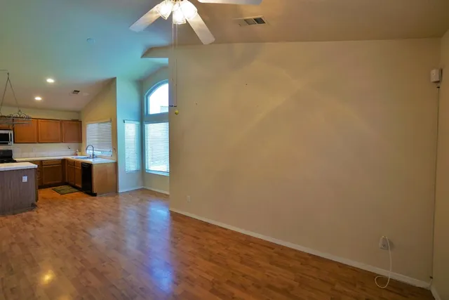 a view of a livingroom with wooden floor and a bathroom