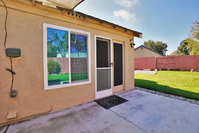 a front view of a house with a yard and potted plants