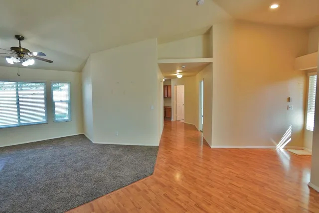 a view of an empty room with a fireplace and a window