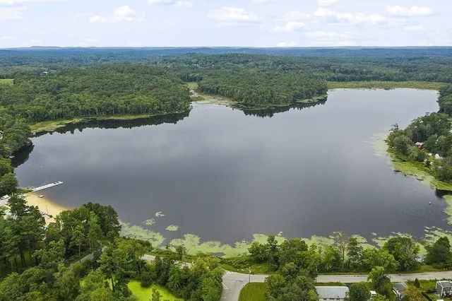 an aerial view of lake and residential houses with outdoor space