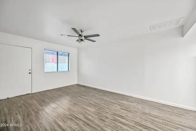 a view of empty room with wooden floor