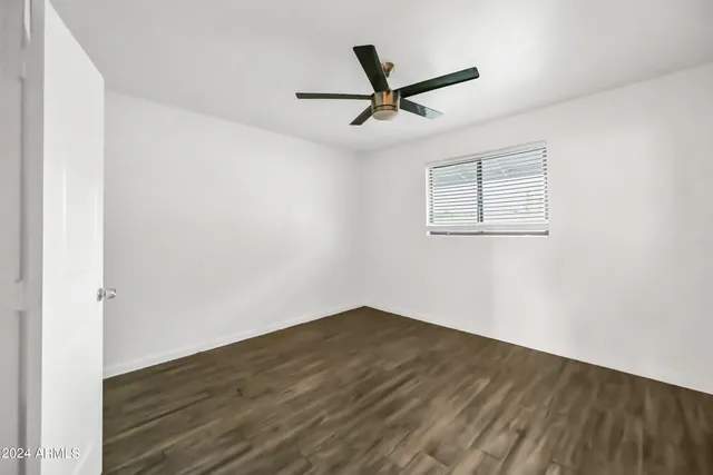 a view of a big room with wooden floor and windows