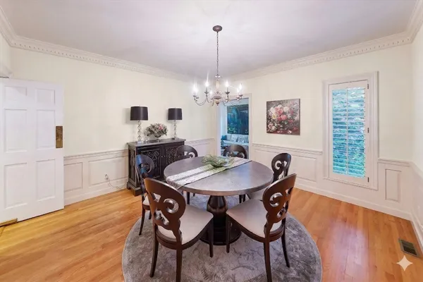 a dining room with furniture a chandelier and wooden floor