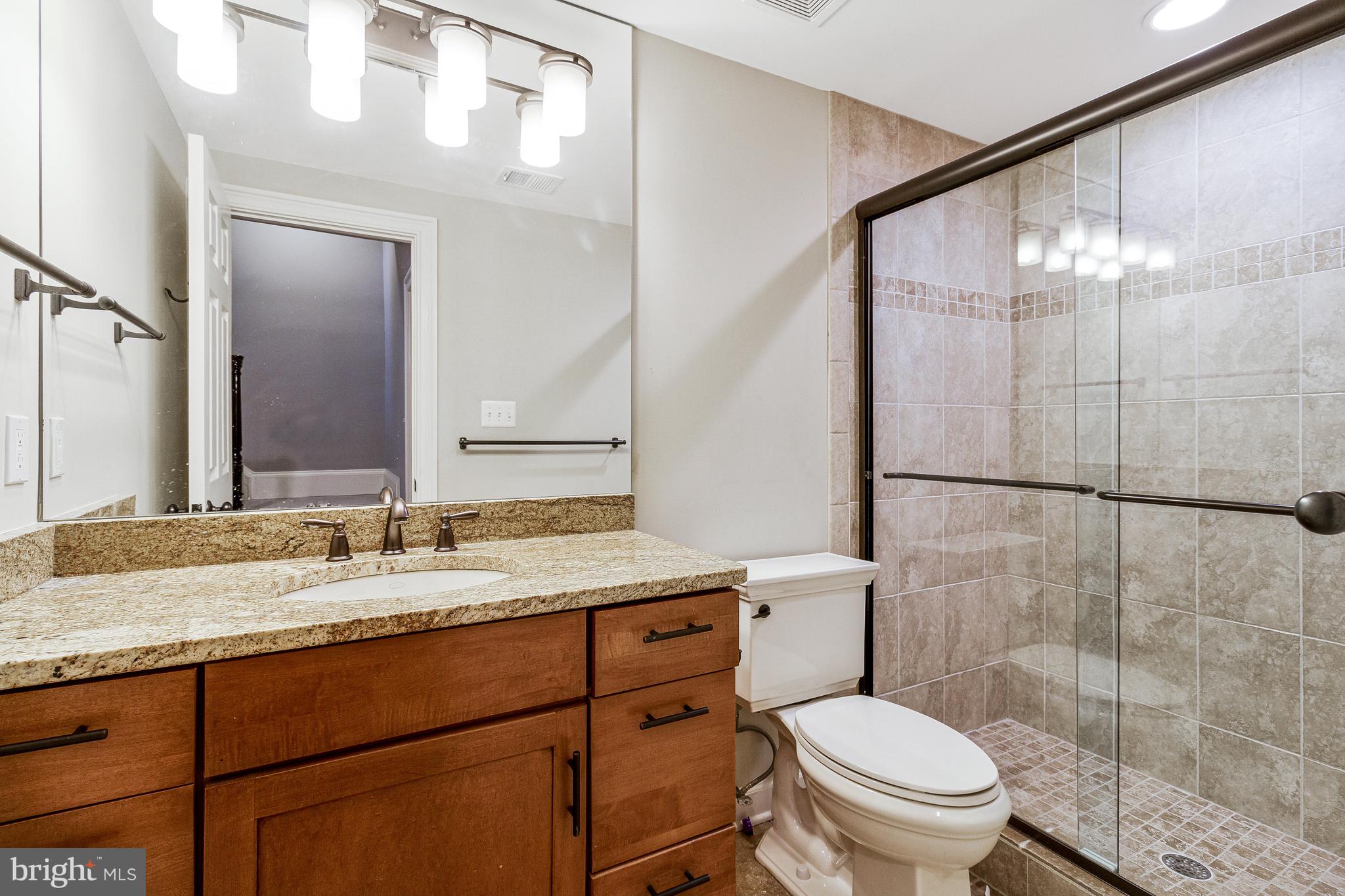 4502 32nd Road North Arlington, VA 22207 - Photo 52 of 57 a bathroom with a granite countertop sink toilet mirror and shower