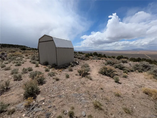 a view of a dry yard with wooden fence