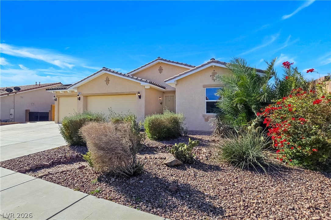2485 Morrow Ridge Place Laughlin, NV 89029 - Photo 4 of 40 A desert-friendly landscape surrounds this warm stucco exterior, featuring a double garage and inviting entrance.