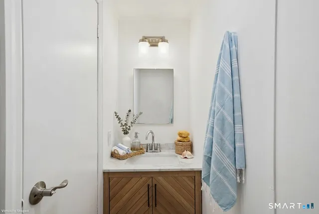 a bathroom with a sink toilet and a mirror