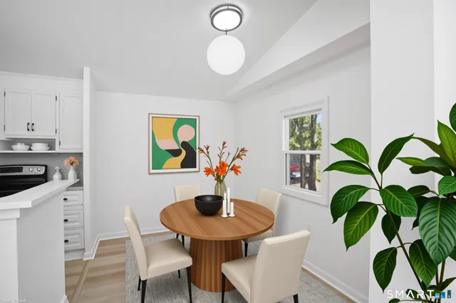 a view of a dining room with furniture wooden floor and a potted plant