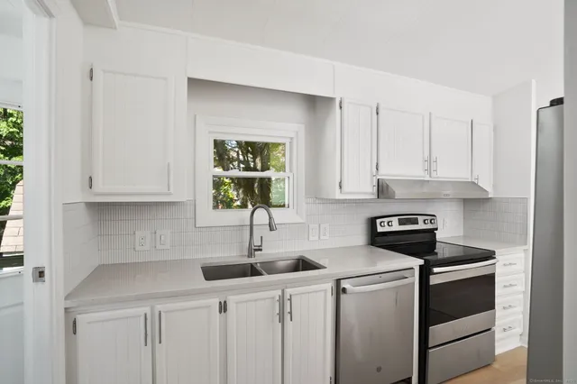 a kitchen with white cabinets and a sink
