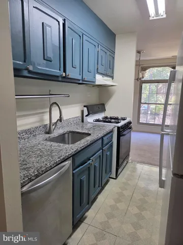 a kitchen with stainless steel appliances granite countertop a sink stove and cabinets