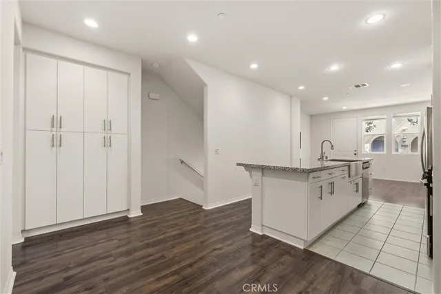 a kitchen with white cabinets and sink