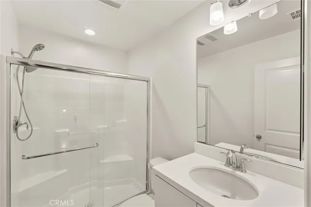 a bathroom with a sink shower and a mirror