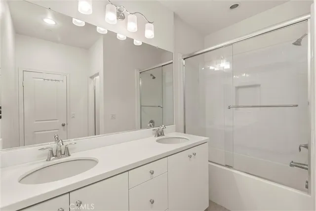a bathroom with a granite countertop sink a large mirror and a bathtub
