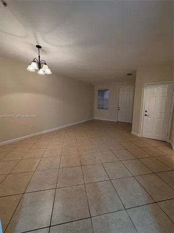 a view of a livingroom with a chandelier fan and windows