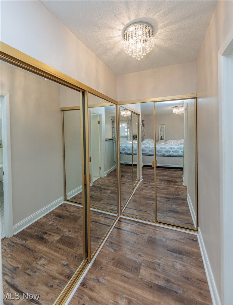 22958 Maple Ridge Road, Unit 209 North Olmsted, OH 44070 - Photo 24 of 38 Unfurnished bedroom with dark wood-type flooring, a chandelier, multiple closets, and a textured ceiling