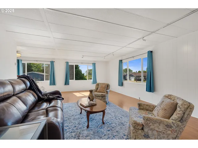 a living room with furniture and a dining table with bookshelf