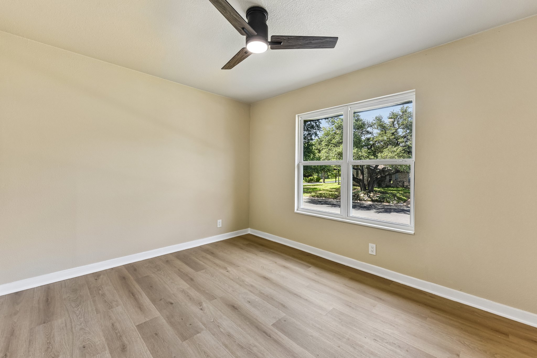 7523 Glenhill Road Austin, TX 78752 - Photo 27 of 38 A quiet bedroom retreat with tree-lined street views and durable wood flooring for easy living.