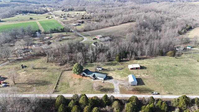 an empty room with wooden floor fireplace and windows