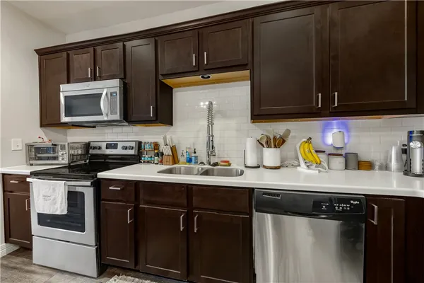 a kitchen with stainless steel appliances granite countertop a sink stove and microwave